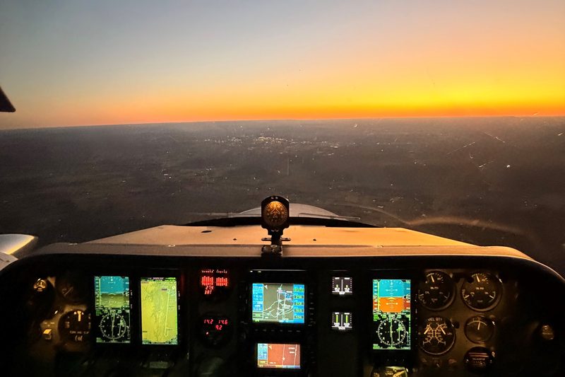 Glass-panel cockpit of the Cessna 310Q N6277Q in flight at sunset